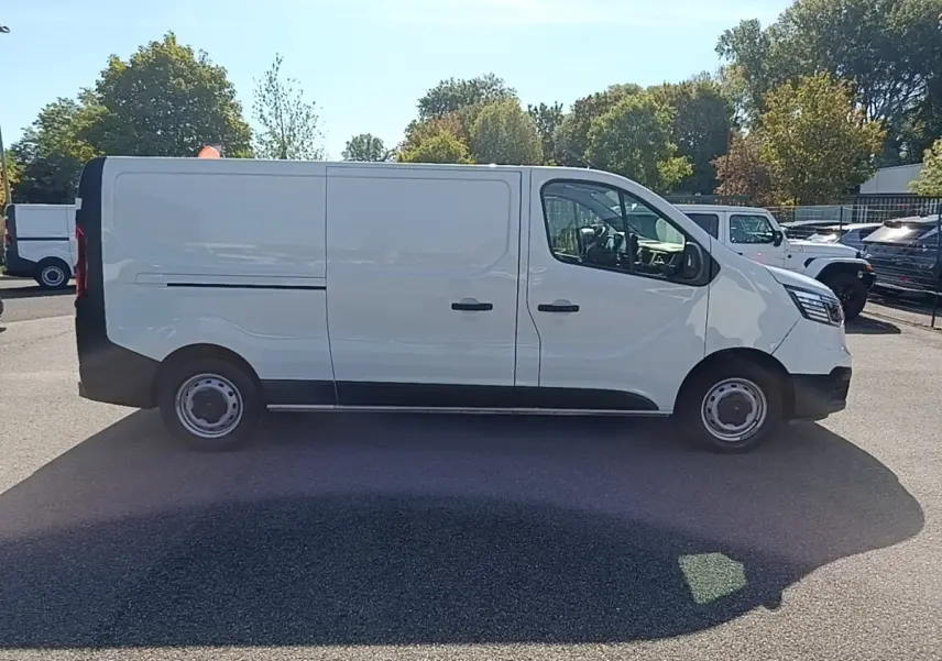 Renault Trafic Fourgon blanc vu de profil côté droit, avec portes latérales et jantes acier noires.