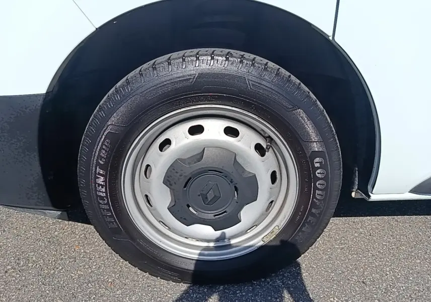 Gros plan sur la roue avant droite d’un Renault Trafic blanc avec jante acier et logo Renault central.