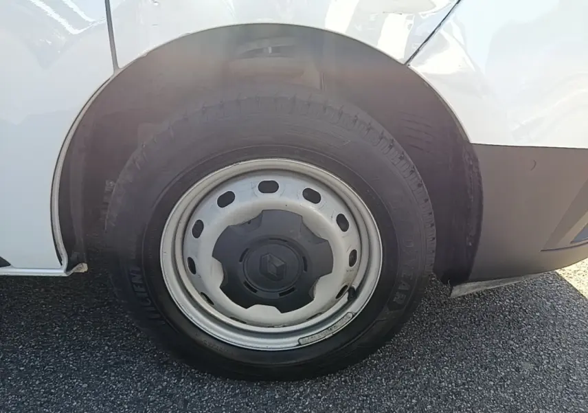 Gros plan sur la roue avant droite en jante acier du Renault Trafic Fourgon blanc, avec logo Renault au centre.