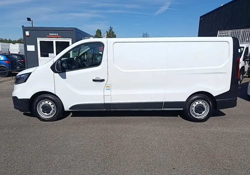 Renault Trafic Fourgon blanc vu de profil côté gauche, avec jantes acier et carrosserie lisse sans fenêtres.