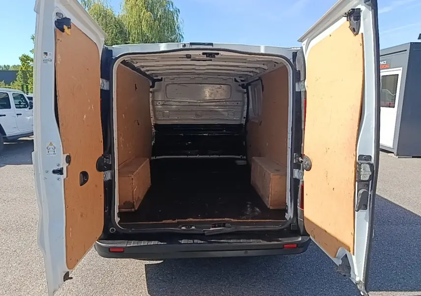 Vue arrière ouverte du Renault Trafic Fourgon blanc 2023 montrant l’espace de chargement vide et les portes battantes.