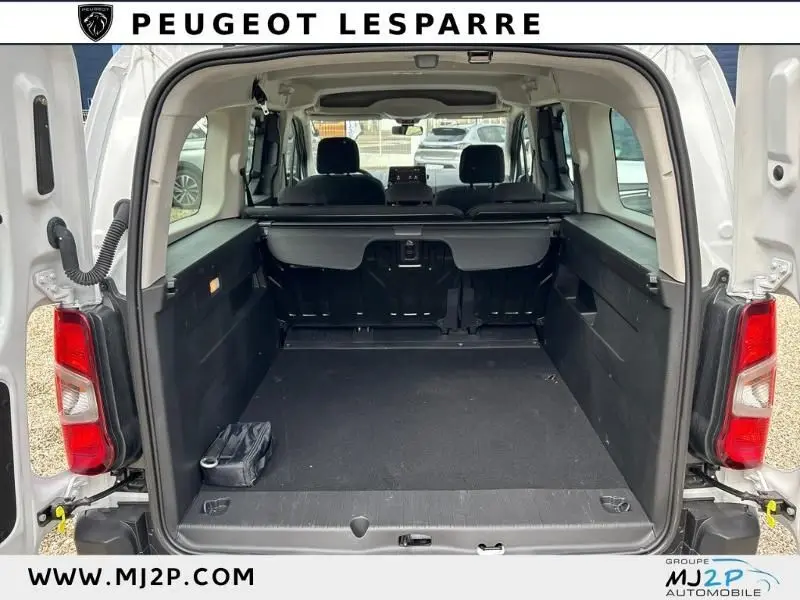 Vue arrière du coffre ouvert du Citroën Berlingo Multispace XL blanc, montrant l'espace de chargement et les sièges arrière.