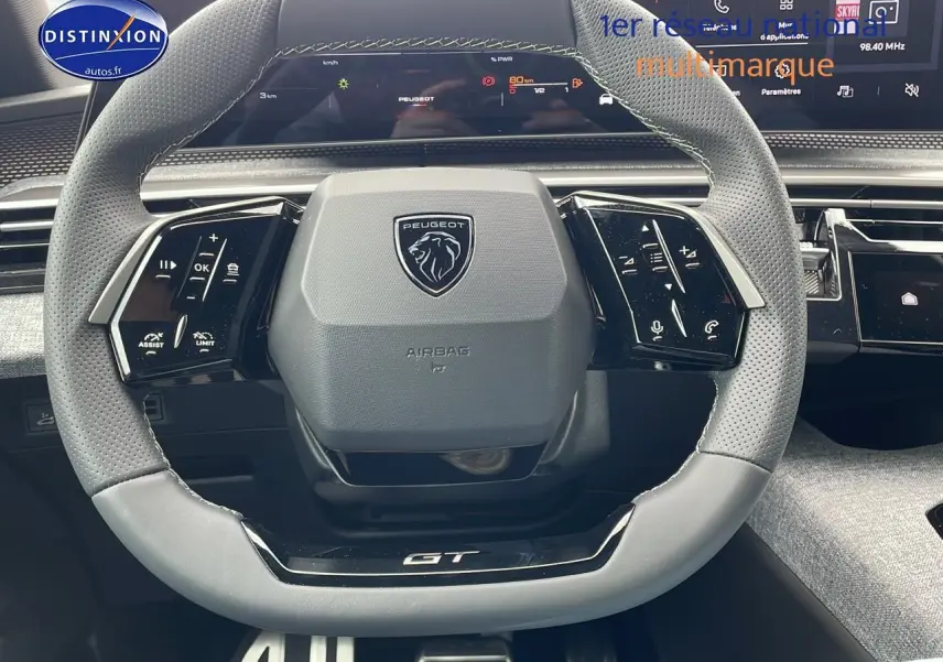 Volant cuir perforé avec logo Peugeot et inscription GT, tableau de bord numérique du 3008 Hybrid 145 gt e-dcs6.