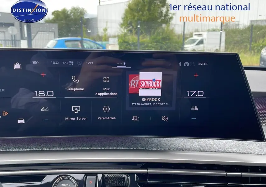 Écran tactile central du tableau de bord du Peugeot 3008 Hybrid 145 GT bleu obsession, affichant la radio Skyrock.