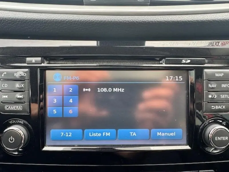 Écran tactile central du Nissan Qashqai 2015 affichant la radio FM avec commandes autour en finition noire brillante