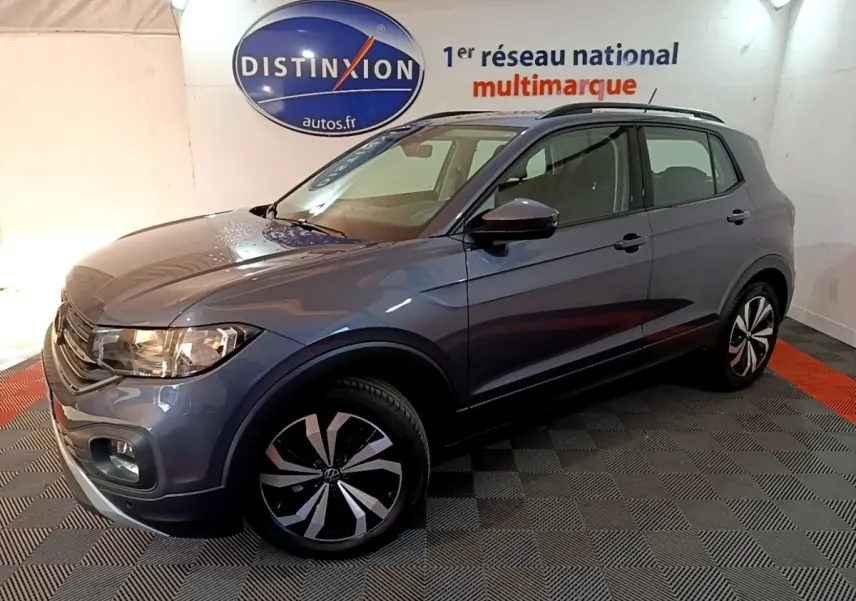 Volkswagen T-Cross gris foncé en 3/4 avant droit, avec jantes distinctives et toit noir en showroom.