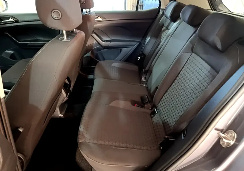 Vue intérieure côté droit montrant la banquette arrière grise foncée du Volkswagen T-Cross 2023 avec appuie-têtes intégrés.