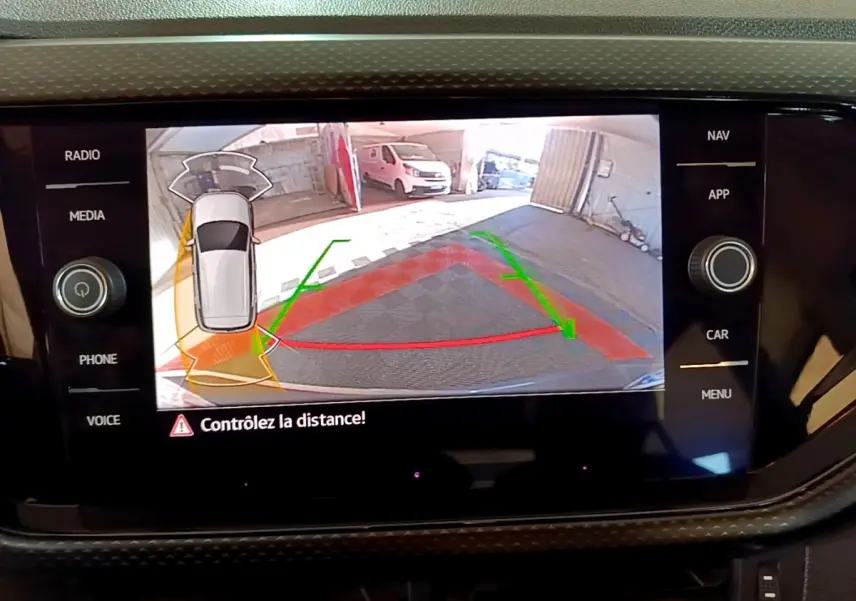 Écran tactile du Volkswagen T-Cross gris foncé montrant la caméra de recul avec guidage de trajectoire en parking.