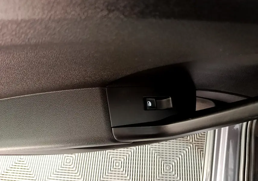 Détail de la poignée intérieure de porte arrière droite du Volkswagen T-Cross gris foncé 2023.