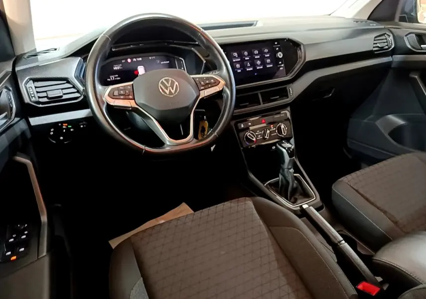 Vue intérieure du tableau de bord et volant cuir multifonctions du Volkswagen T-Cross 2023, ambiance noire et moderne.