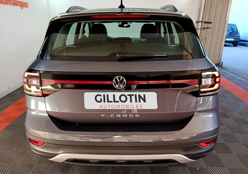 Vue arrière d’un Volkswagen T-Cross gris foncé 2023 avec feux LED et logo VW bien visibles.