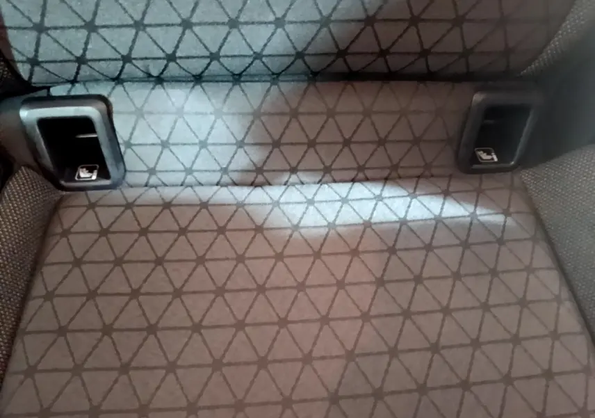 Gros plan sur la banquette arrière gris foncé du Volkswagen T-Cross avec fixation Isofix visible de face.