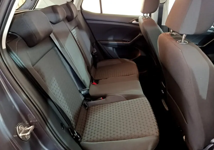Vue intérieure côté gauche sur la banquette arrière grise foncée du Volkswagen T-Cross 2023 avec appuie-têtes et ceintures visibles.