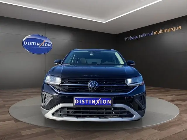 Vue de face du Volkswagen T-Cross noir 2025 avec calandre noire et détails argentés, en showroom Distinxion.