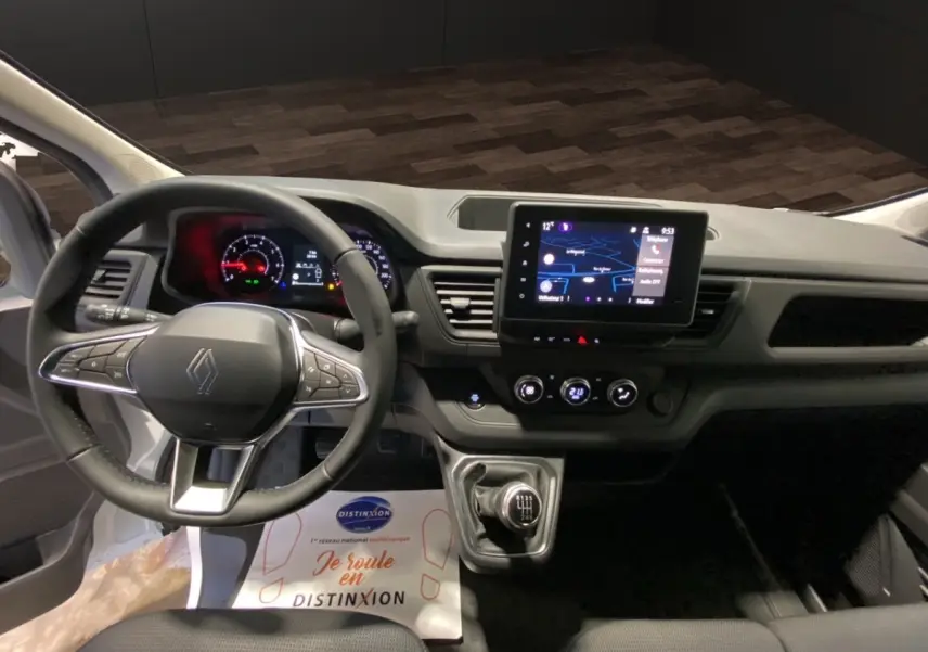 Vue intérieure du tableau de bord du Renault Trafic Fourgon 2025 avec volant multifonctions et écran tactile central.