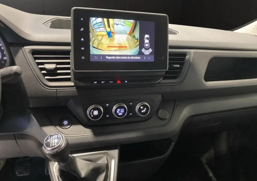 Vue rapprochée du tableau de bord du Renault Trafic Fourgon 2025, avec écran tactile et levier de vitesses manuel.