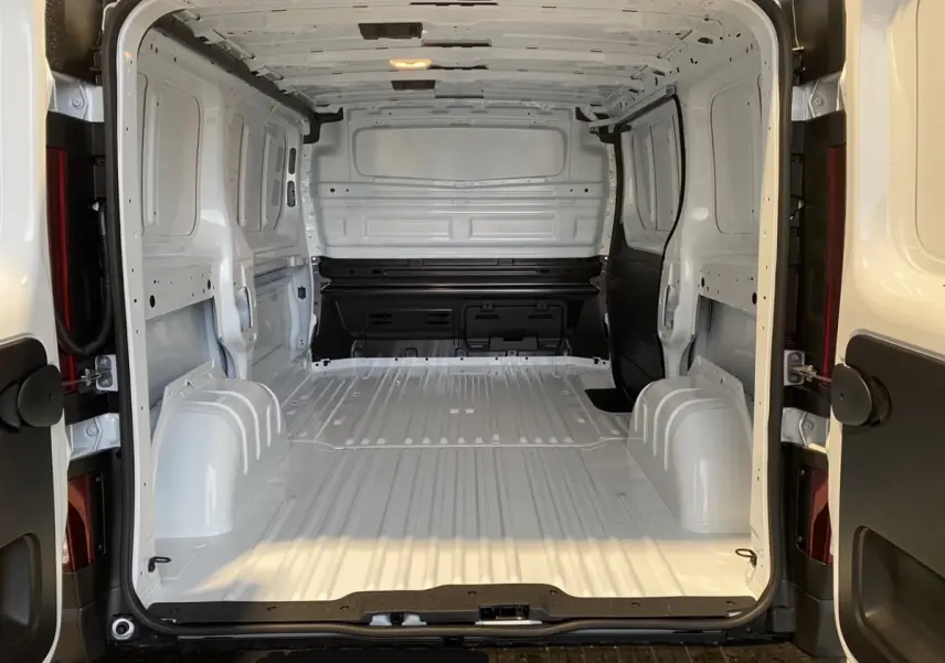 Vue arrière du Renault Trafic Fourgon blanc montrant l’espace de chargement vide et la cloison pleine intérieure.