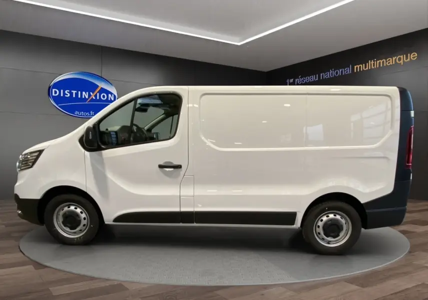 Vue de profil côté gauche du Renault Trafic Fourgon blanc, avec jantes acier et protections noires sur le bas de caisse.