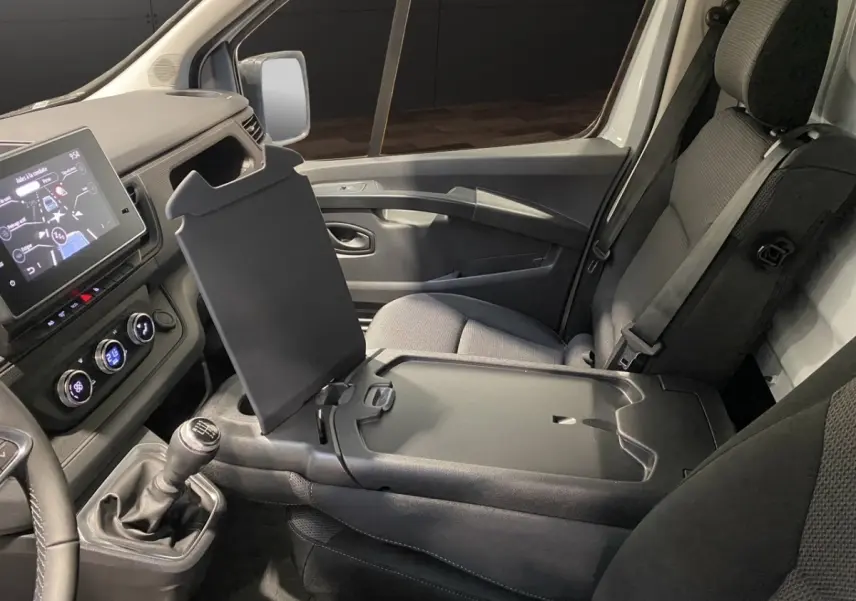 Vue intérieure côté passager du Renault Trafic Fourgon 2025 blanc, montrant la console centrale relevée et tableau de bord numérique.