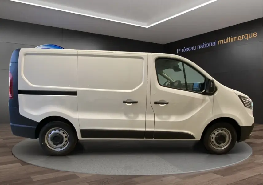 Vue de profil côté gauche du Renault Trafic Fourgon blanc, avec portes latérales pleines et jantes acier simples.