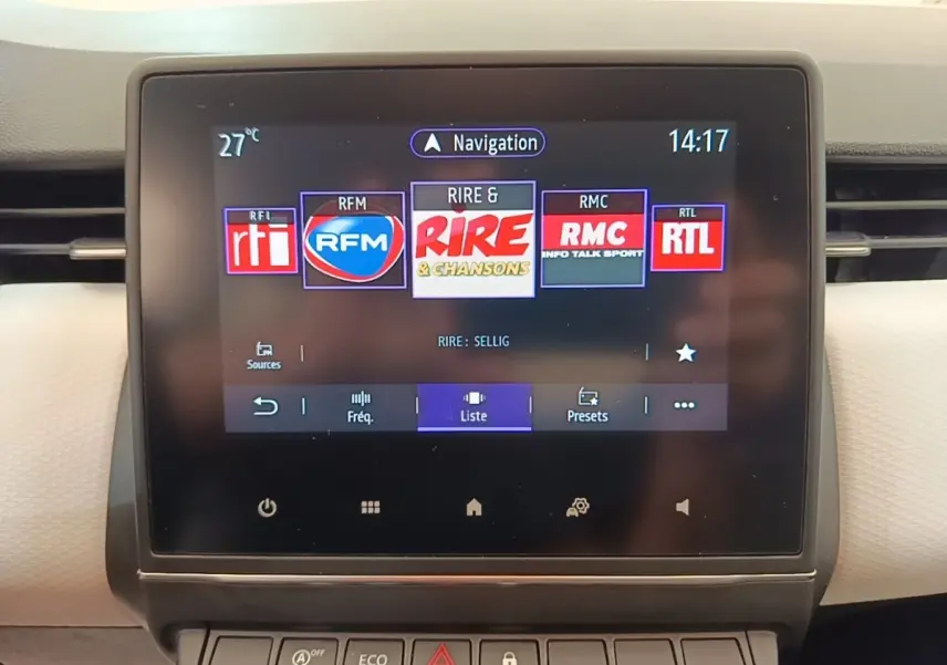 Écran tactile central de la Renault Clio blanche 2023 affichant les stations radio avec interface moderne.