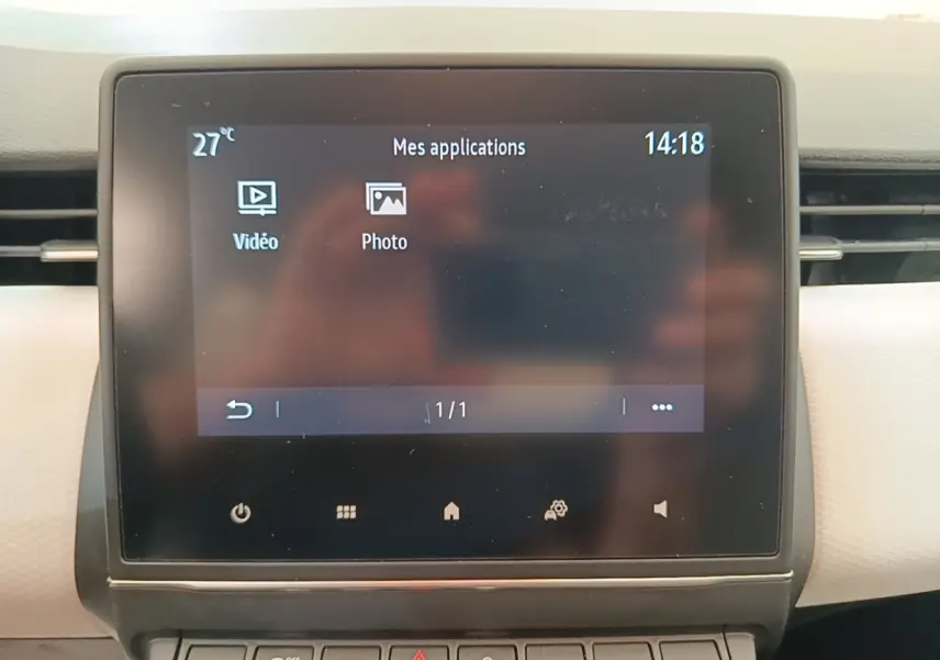 Écran tactile central de la Renault Clio blanc 2023 affichant les applications vidéo et photo.