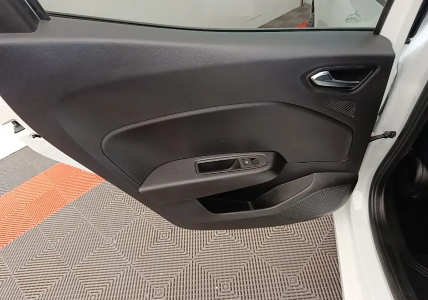 Vue intérieure de la porte avant gauche d'une Renault Clio blanche, avec panneau noir et commande de vitre électrique.
