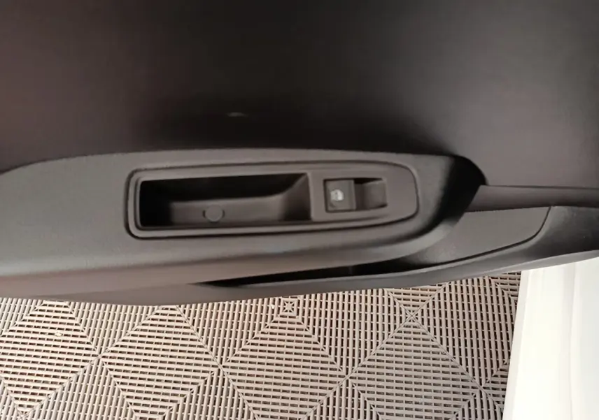 Détail de la poignée intérieure de porte côté droit de la Renault Clio blanche 2023 avec bouton de verrouillage.