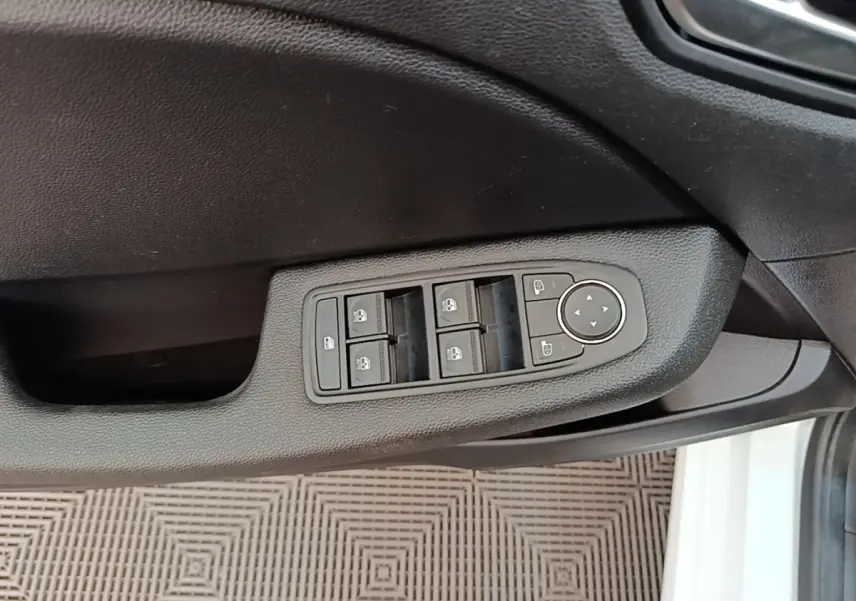Commande des vitres électriques et réglages des rétroviseurs sur la porte côté conducteur d'une Renault Clio blanche 2023.