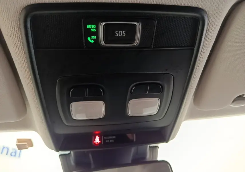 Vue intérieure du plafonnier avec bouton SOS éclairé et commandes d'éclairage dans une Renault Clio blanche 2023.