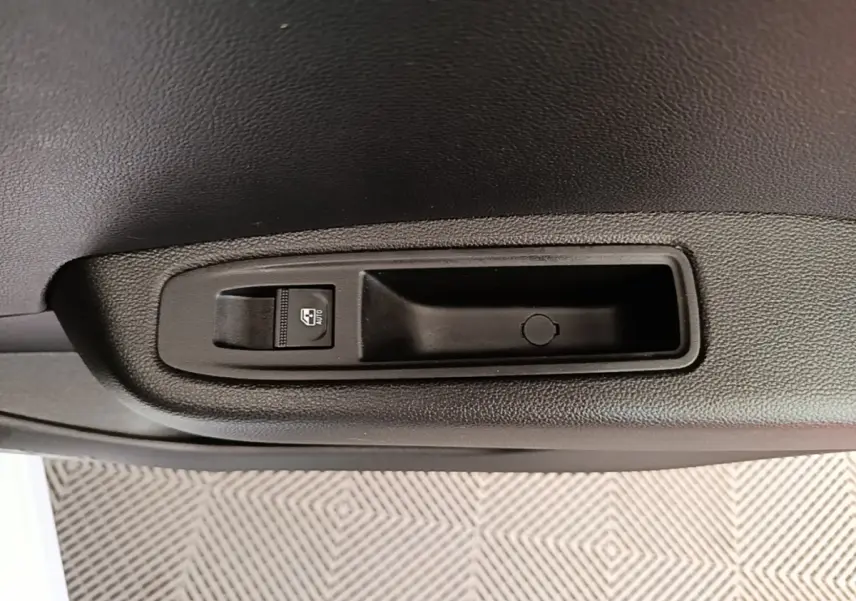 Gros plan sur la commande de lève-vitre électrique côté intérieur d'une Renault Clio blanche, finition Evolution TCe 90.