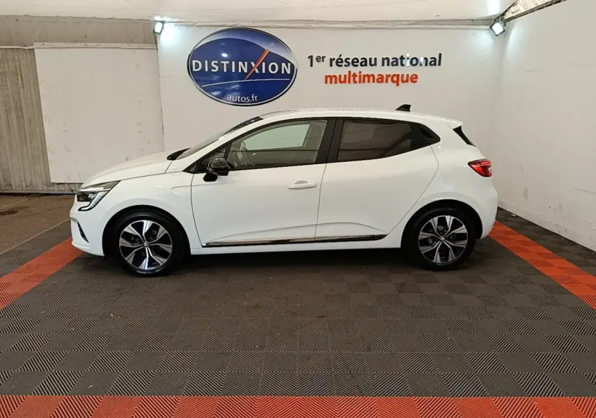 Profil côté gauche d'une Renault Clio blanche 2023 Evolution TCe 90, avec jantes alliage et vitres teintées.