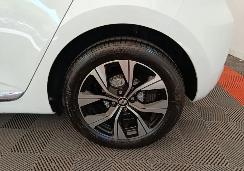 Gros plan sur la roue arrière droite blanche d’une Renault Clio 2023 avec jante alliage noire et argentée.