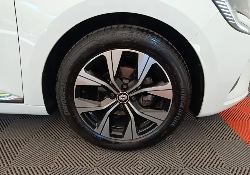 Gros plan sur la roue avant droite de la Renault Clio blanche 2023, avec jante alliage au design moderne.