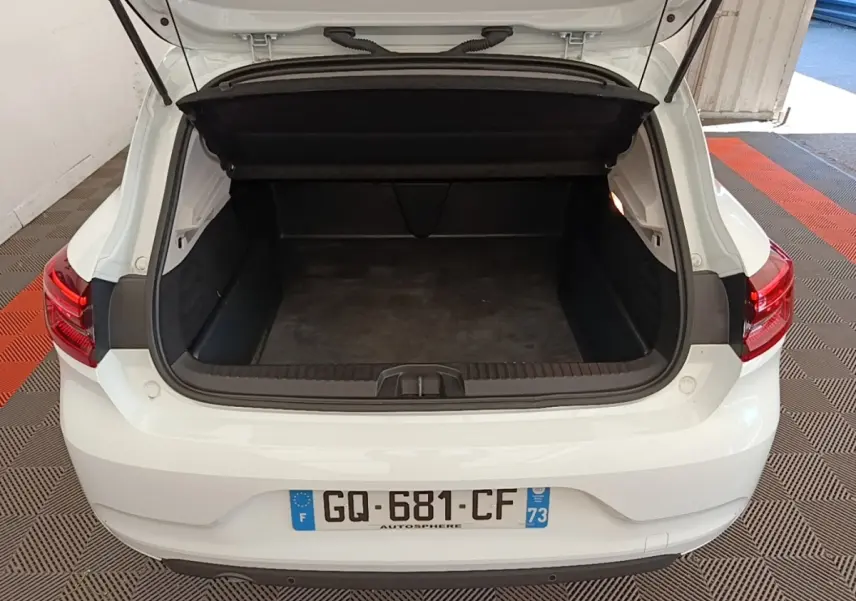Vue arrière d'une Renault Clio blanche 2023 avec coffre ouvert montrant l'espace de chargement vide.
