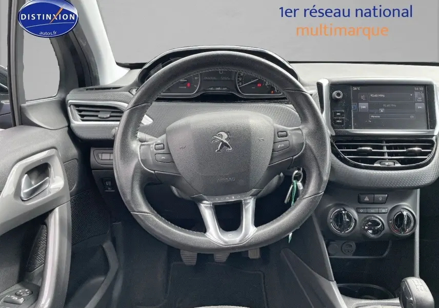 Vue intérieure centrée sur le volant Peugeot 2008 noir métal, tableau de bord et console avec écran tactile et commandes climatiques.