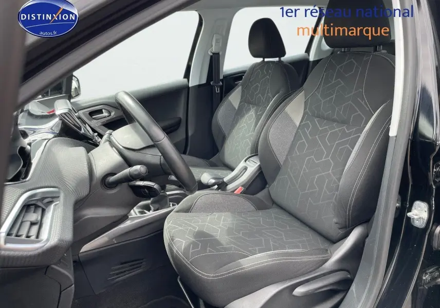 Vue intérieure côté conducteur du Peugeot 2008 noir métal 2016, mettant en valeur les sièges tissu gris et le tableau de bord.