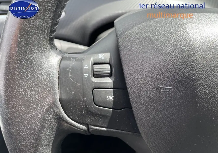 Gros plan sur la partie gauche du volant noir du Peugeot 2008 2016, avec commandes audio intégrées.