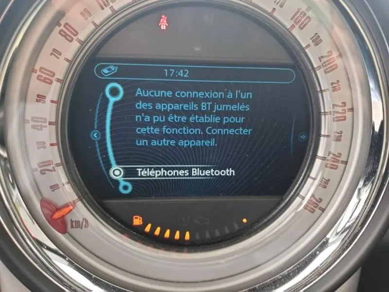Gros plan sur le tableau de bord numérique du MINI Countryman 2014 affichant un message Bluetooth d'absence de connexion.