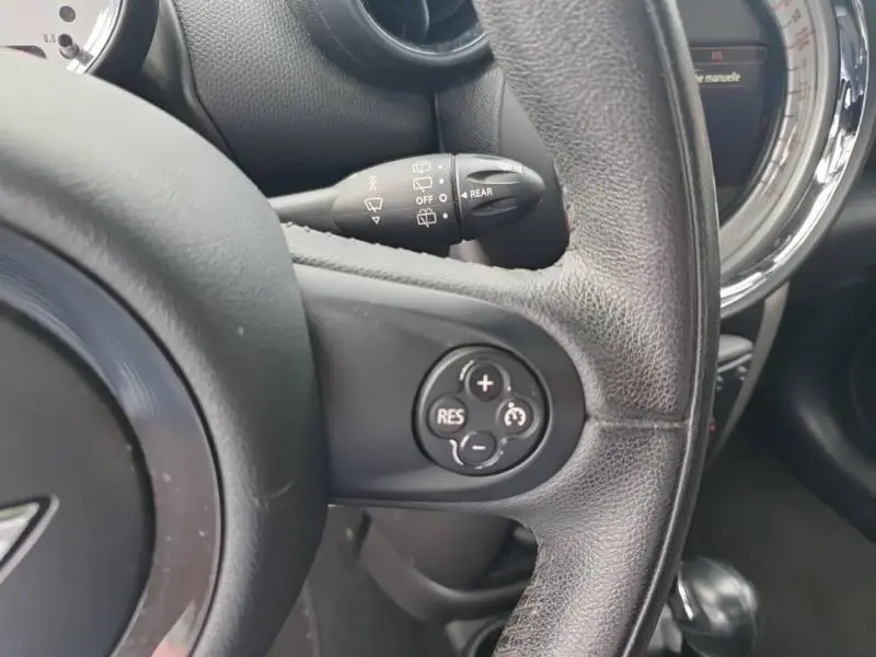 Gros plan sur le volant en cuir noir de la MINI Countryman Royal Grey 2014 avec commandes de régulateur de vitesse.