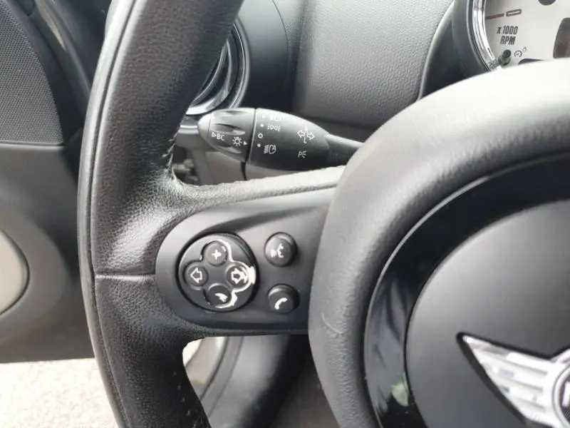 Gros plan sur le volant cuir noir de la MINI Countryman Royal Grey 2014, avec commandes audio intégrées.