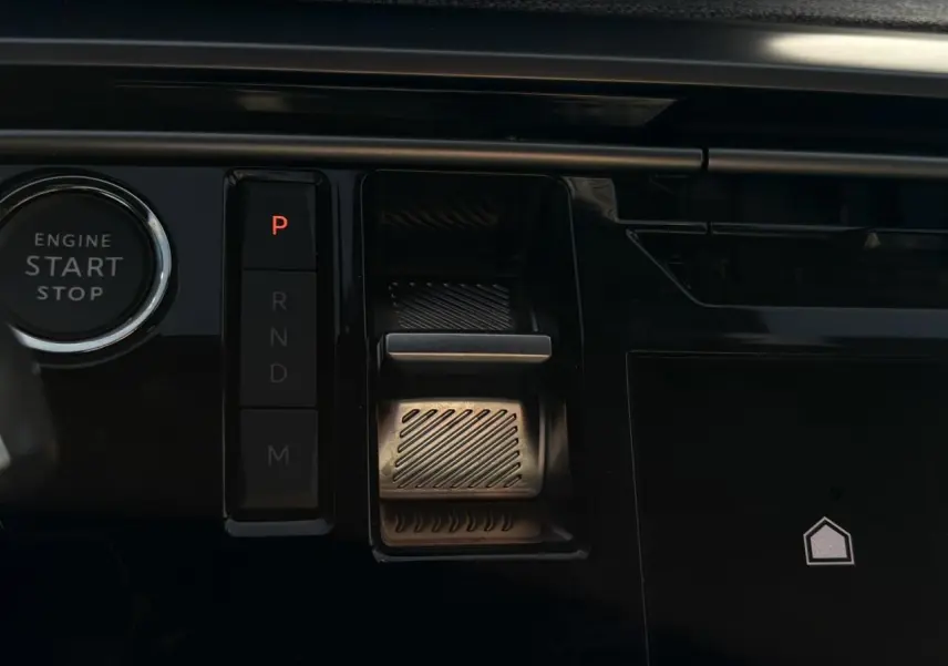 Gros plan sur la console centrale noire du Peugeot 3008 Hybrid avec bouton start/stop et commande de boîte automatique digitale.