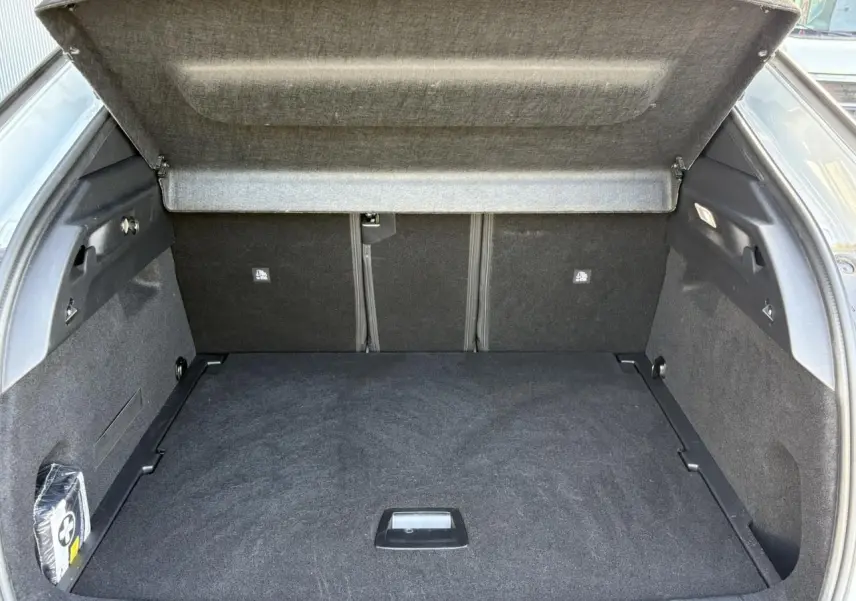 Coffre ouvert vu de l'arrière d'un Peugeot 3008 blanc, montrant un espace de chargement propre et spacieux.