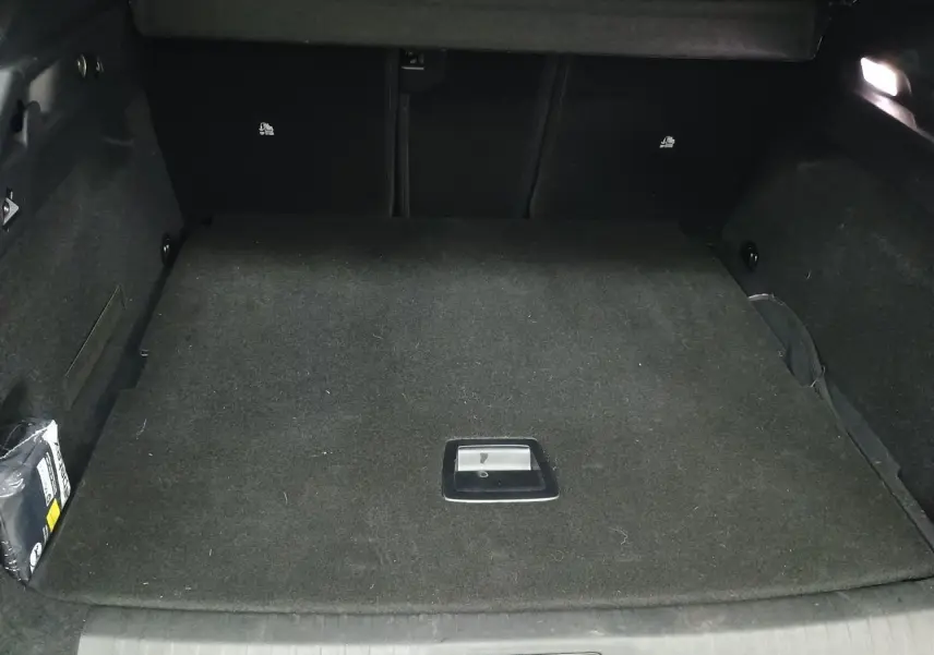 Gros plan sur le volant cuir noir du Peugeot 3008 Hybrid 2025 avec commandes intégrées et logo lion central.