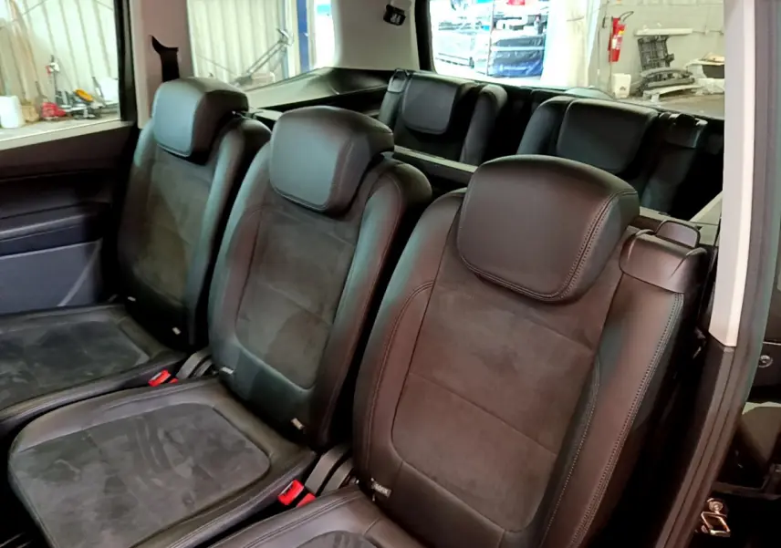 Vue intérieure sur les sièges arrière individuels en cuir noir du Volkswagen Sharan 2017, avec plancher plat visible.