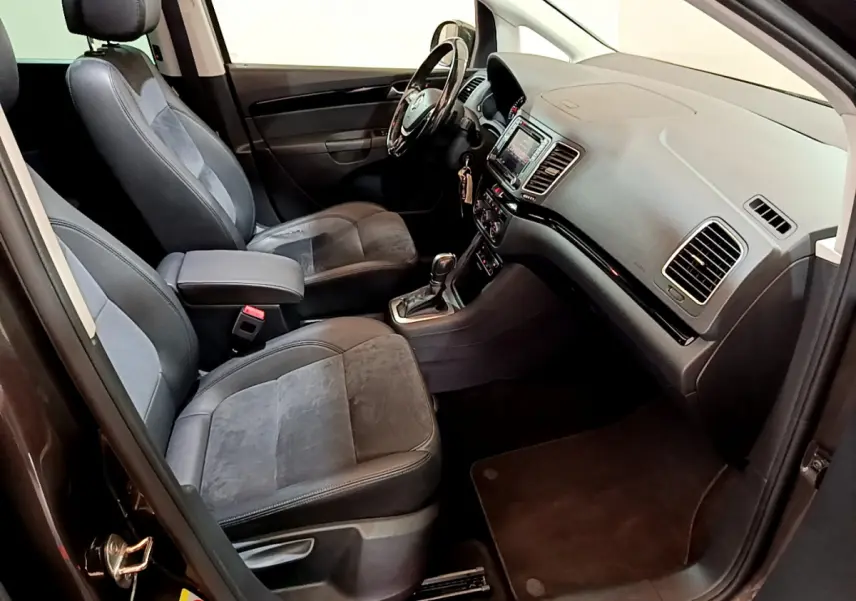 Vue intérieure côté avant droit du Volkswagen Sharan marron, montrant sièges en cuir et tableau de bord avec écran tactile.