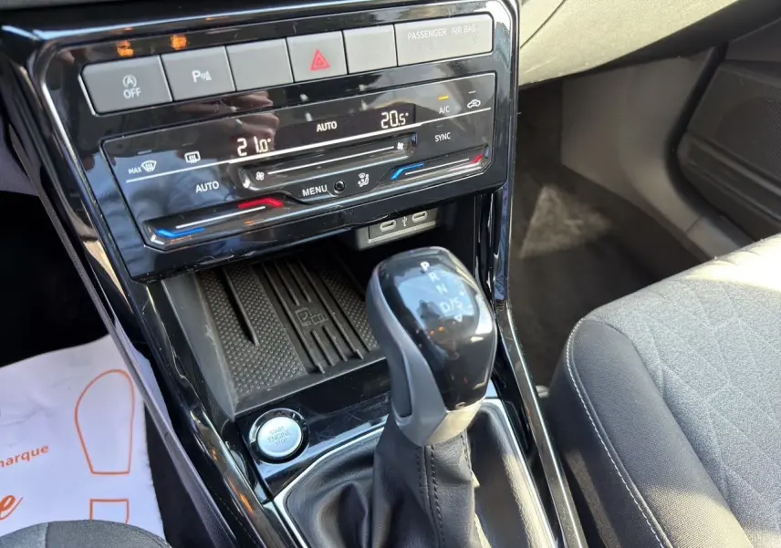 Vue rapprochée de la console centrale du Volkswagen T-Cross 2025, avec levier de vitesse DSG et climatisation tactile.
