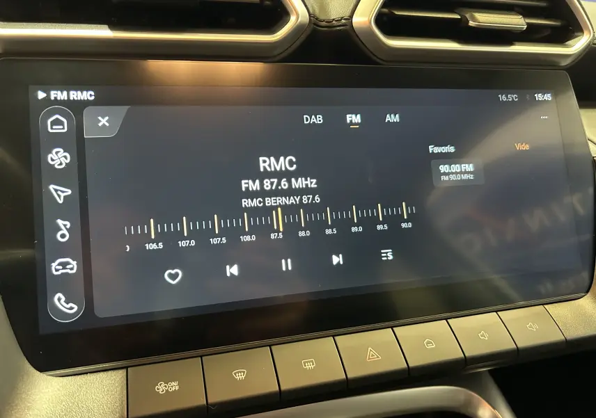 Écran tactile central du MG ZS 1.5 Hybrid+ 197 Luxury en Dover White, affichant la radio FM sur fréquence 87,6 MHz.