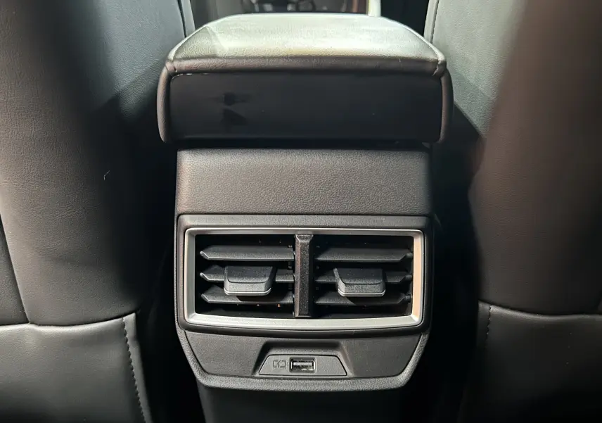 Vue rapprochée de la console arrière noire avec bouches d’aération et port USB du MG ZS 1.5 Hybrid+ Dover White.