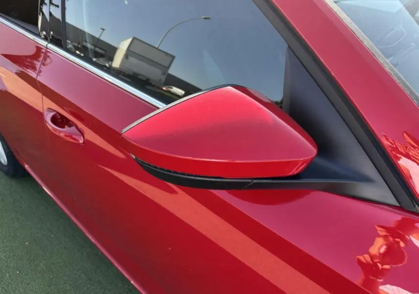 Rétroviseur côté gauche rouge Velvet Metal de la Skoda Scala 2024, vue rapprochée sur la portière avant.